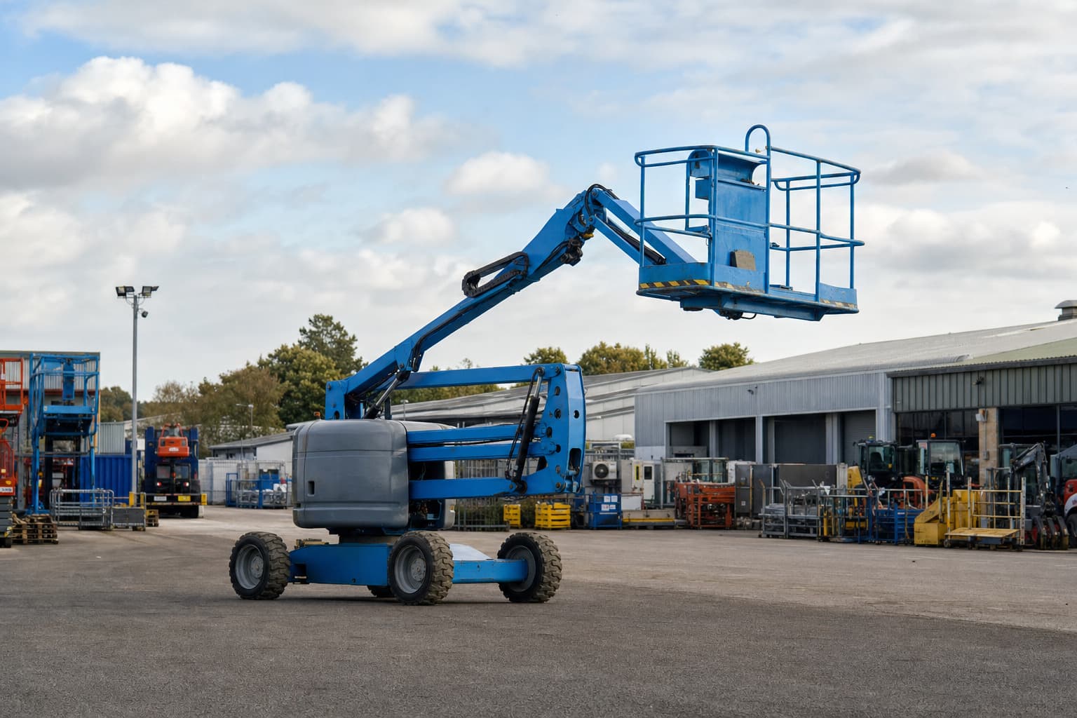 An articulated boom lift in an equipment service yard